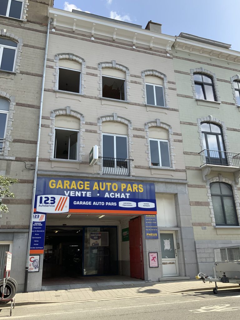 Immeuble enduit à la chaux au-dessus d'un garage