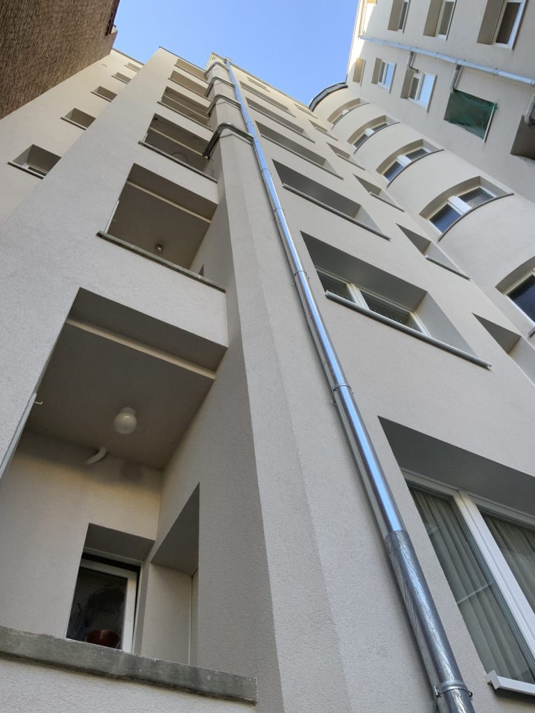 Façade d'immeuble isolée et enduite, vue en contre-plongée
