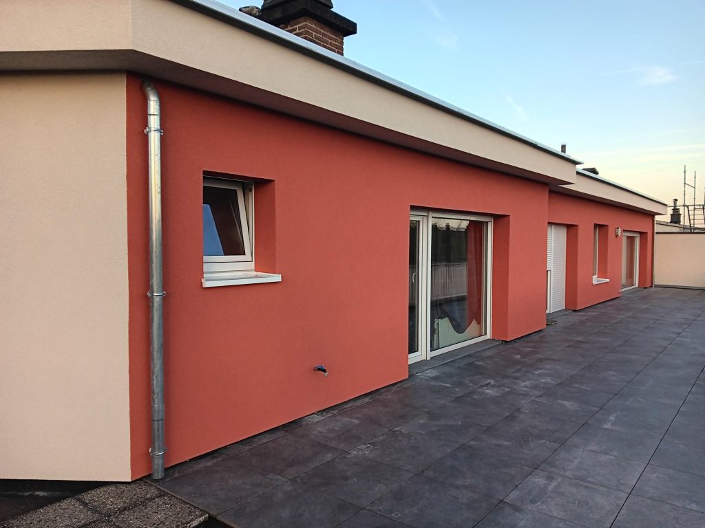 Façade avec un enduit rouge en terrasse